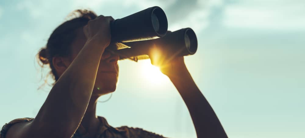 young woman looking through binoculars